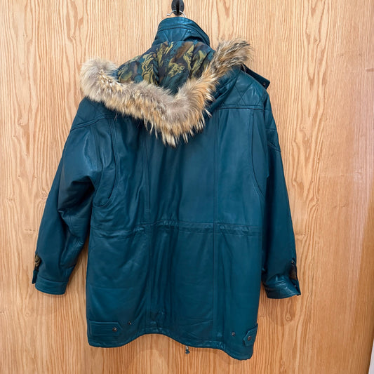 Blue parka jacket with fur-lined hood on a wooden surface
