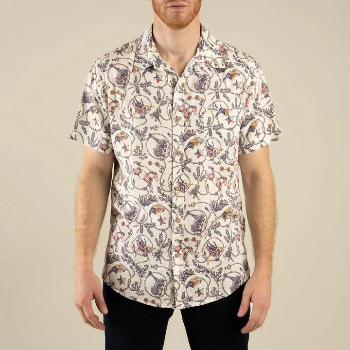 Person wearing a patterned shirt with a neutral background