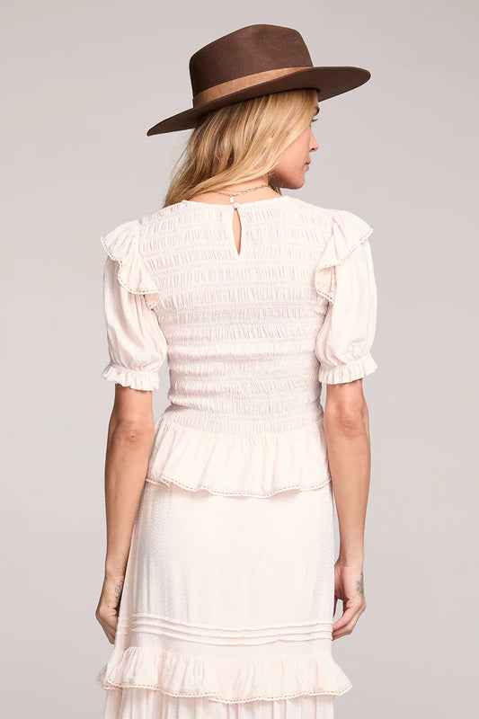 Woman wearing a white dress and brown hat on a gray background