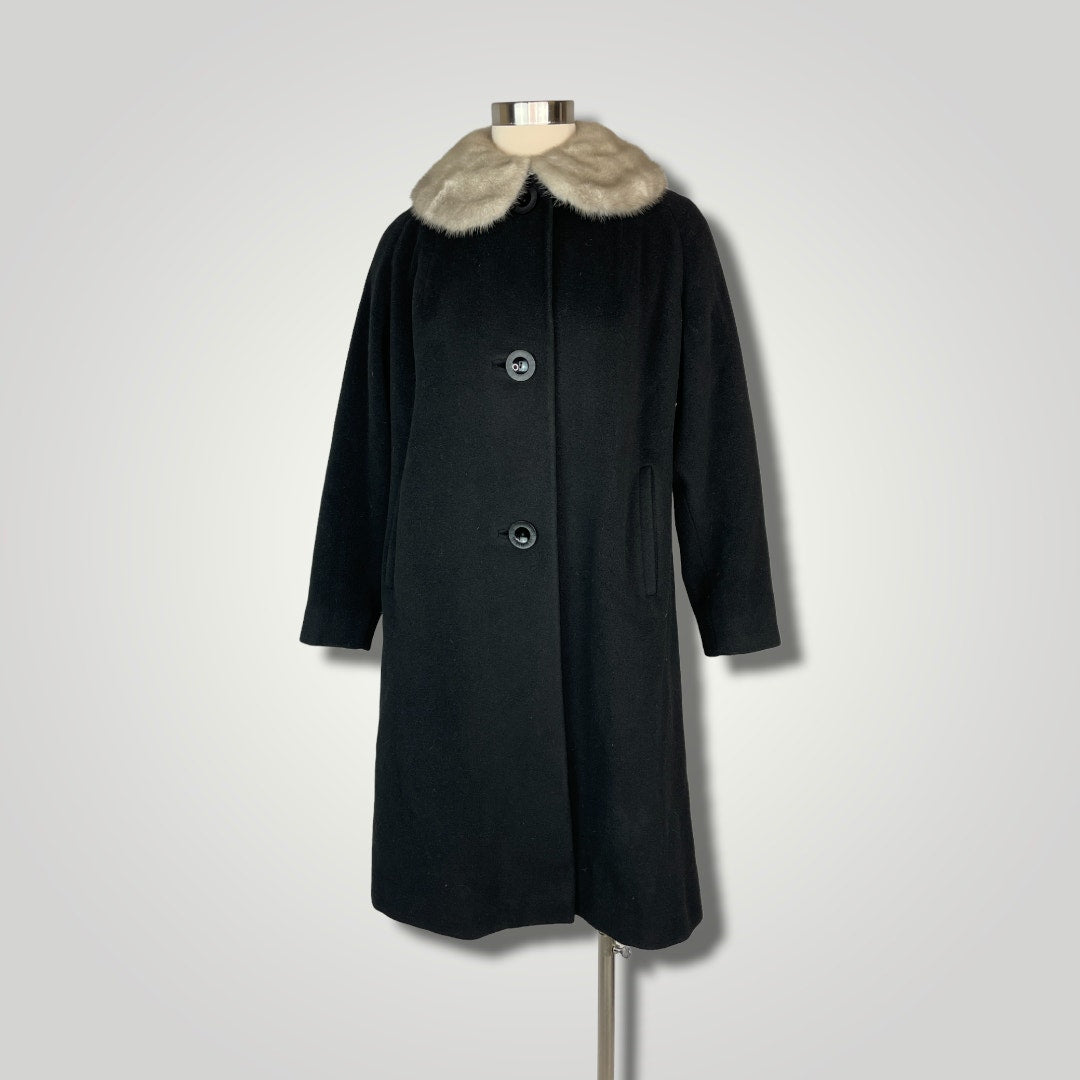 Black coat with fur collar on a mannequin against a light gray background