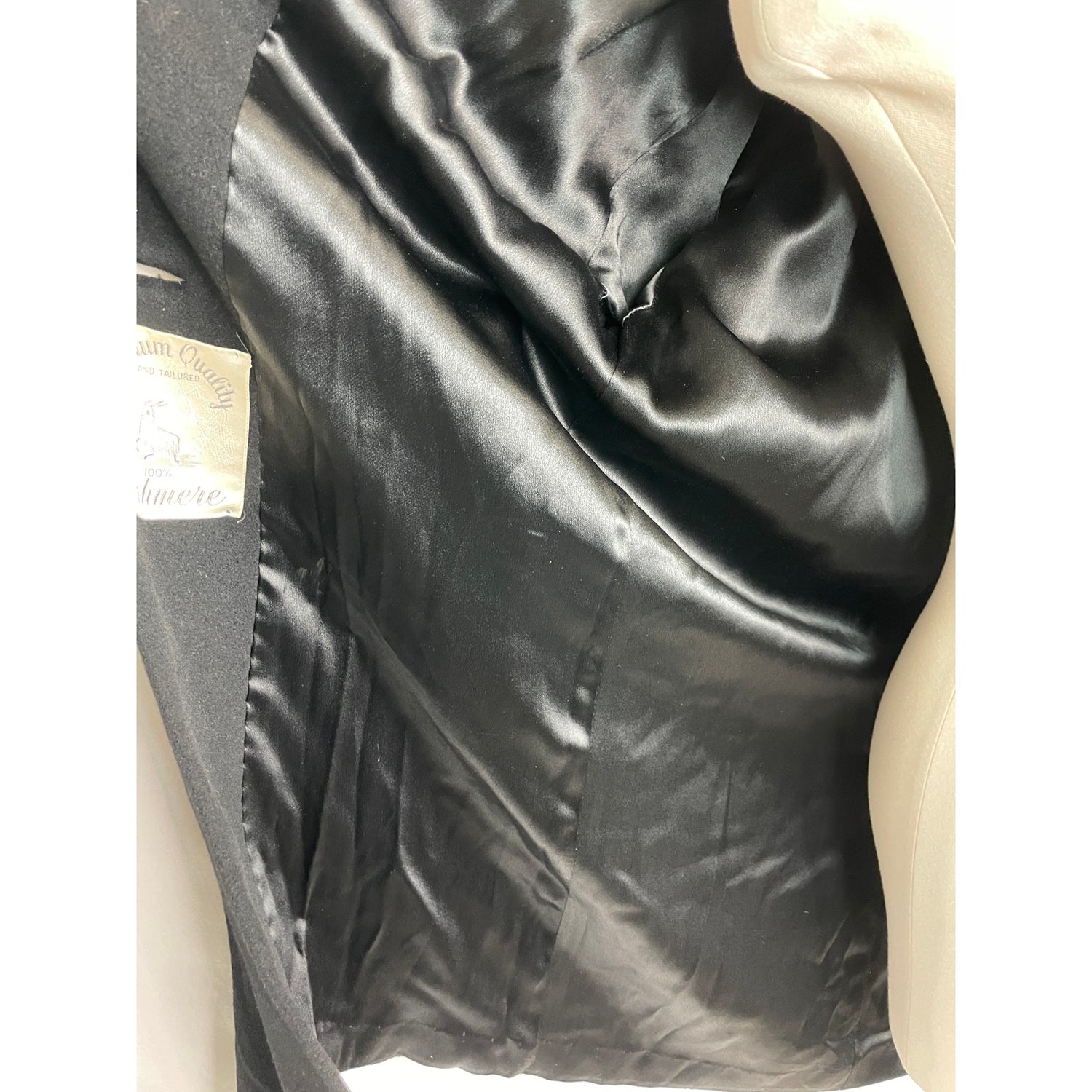 Close-up of a black satin garment with a visible label.