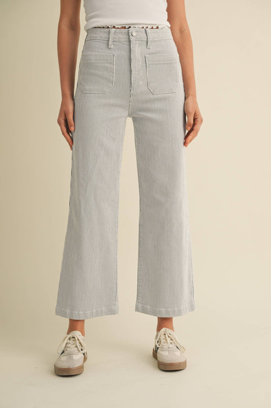 Person wearing light gray striped pants on a beige background