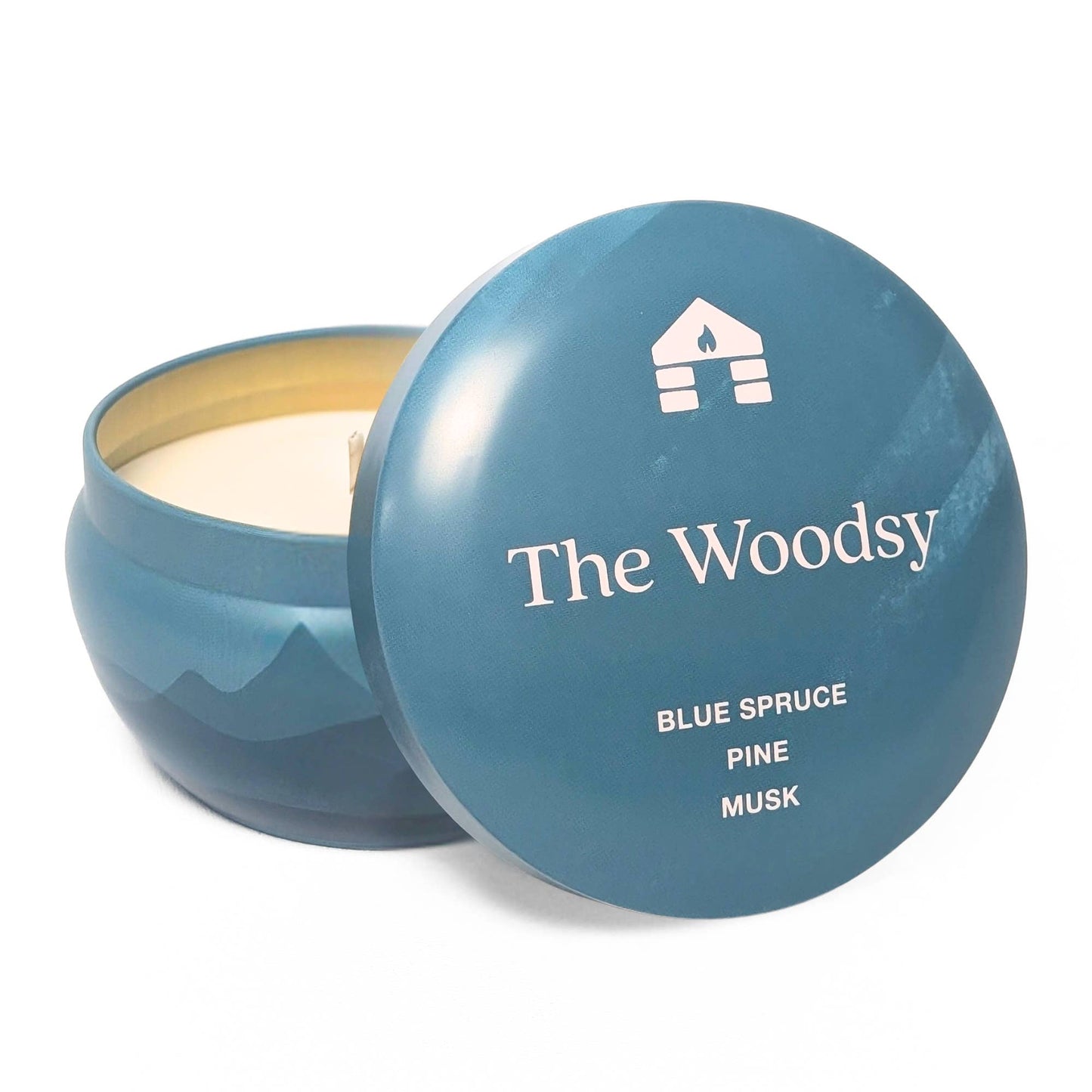 Blue candle jar with lid featuring 'The Woodsy' brand on a white background