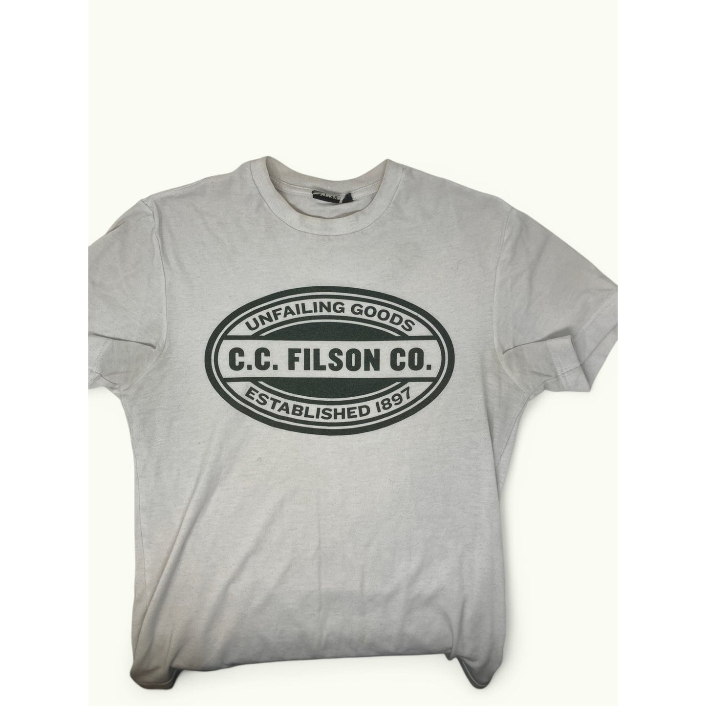 A light gray short-sleeve t-shirt with a black oval graphic on the chest that reads 'UNFAILING GOODS C.C.