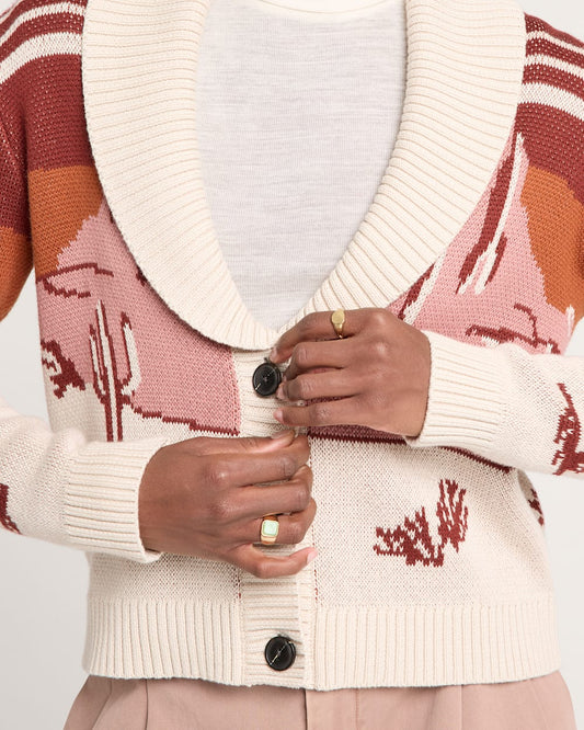 Close-up of a person wearing a patterned cardigan with a plain background