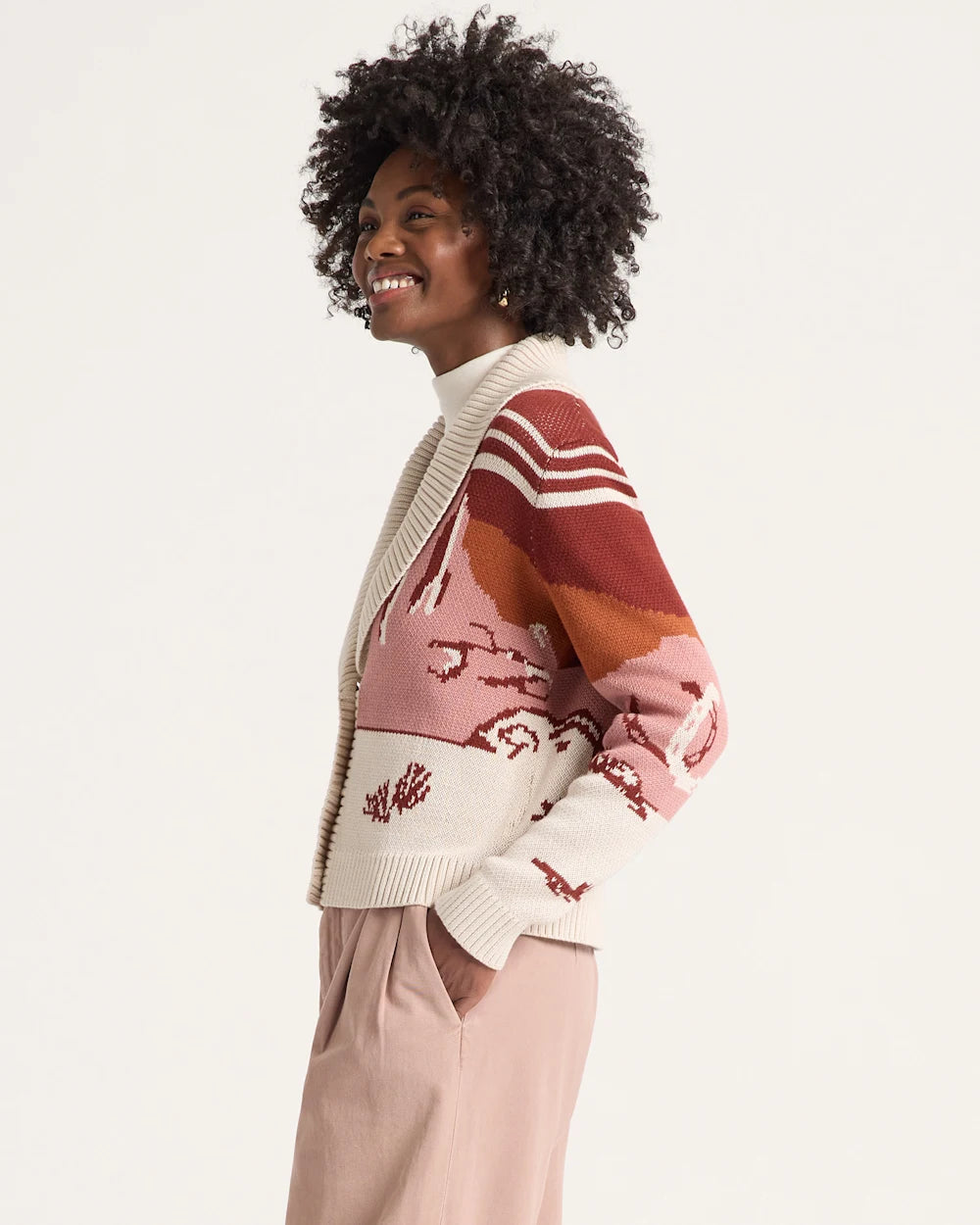 Woman wearing a colorful sweater with a white background