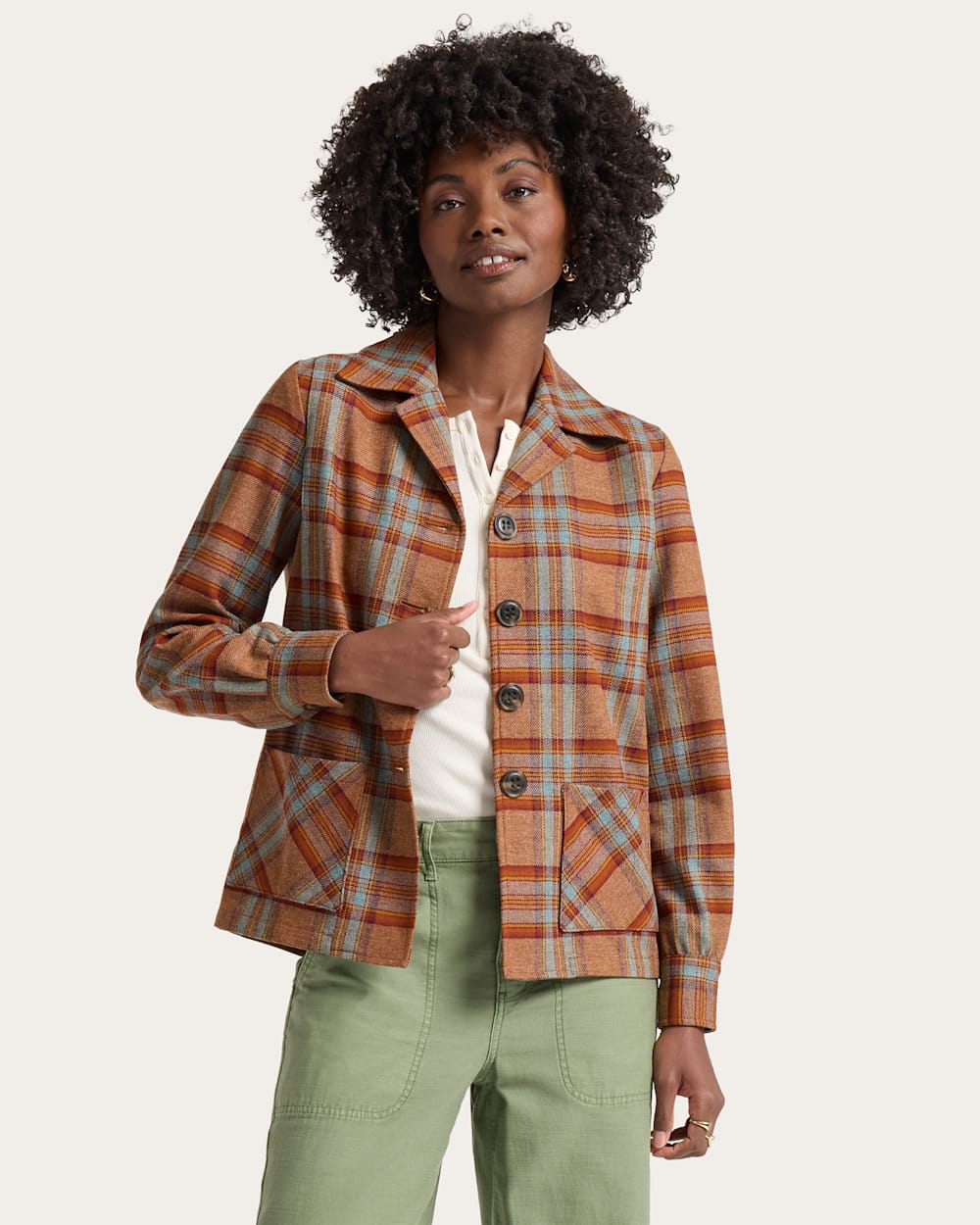 Woman wearing a plaid jacket with a neutral background